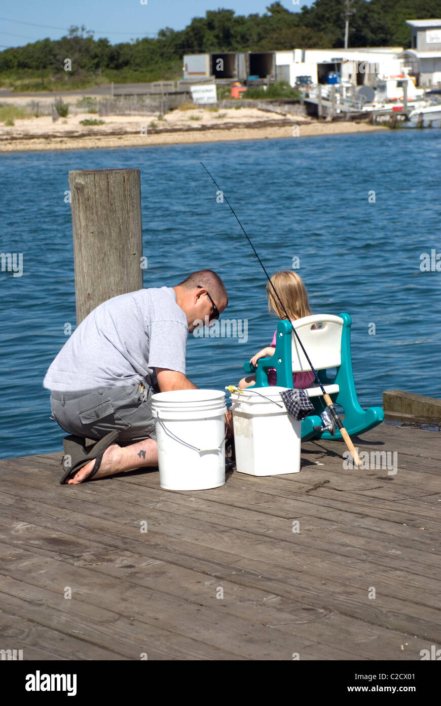 Father and daughter on fishing pier, Montauk, Long Island, NY Stock