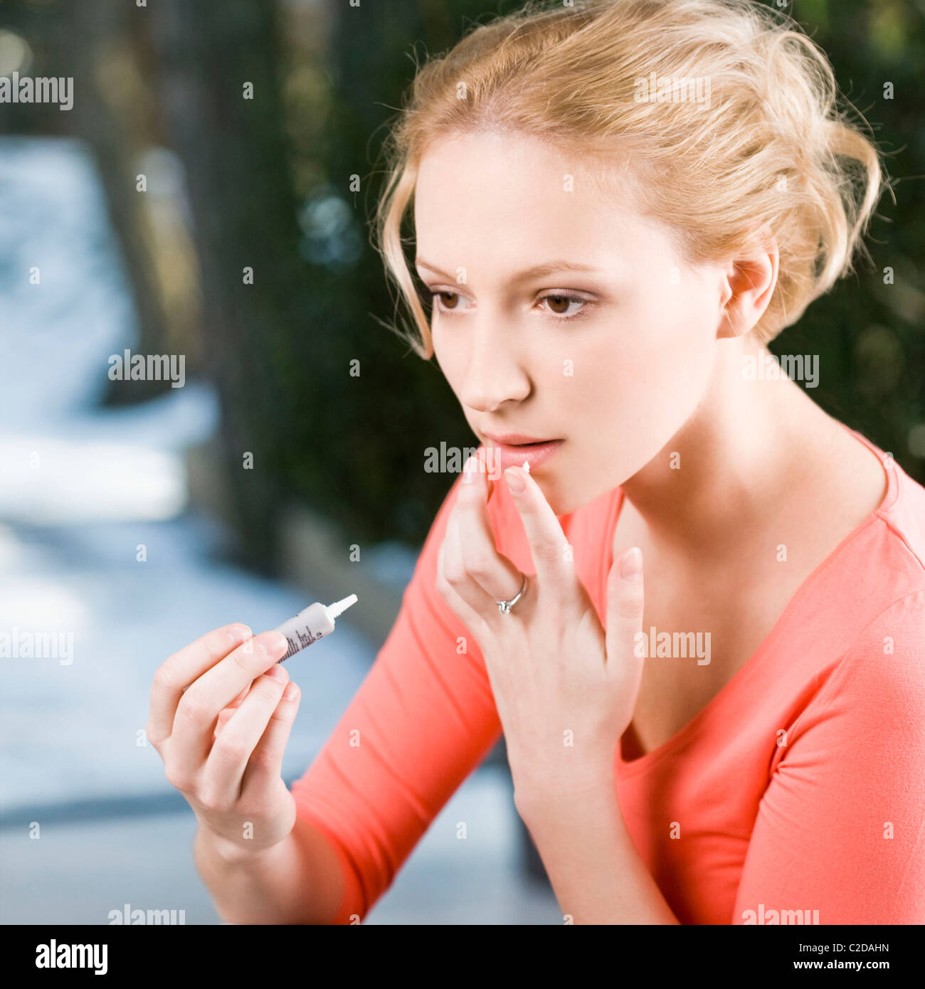 Woman applying ointment for cold sores Stock Photo