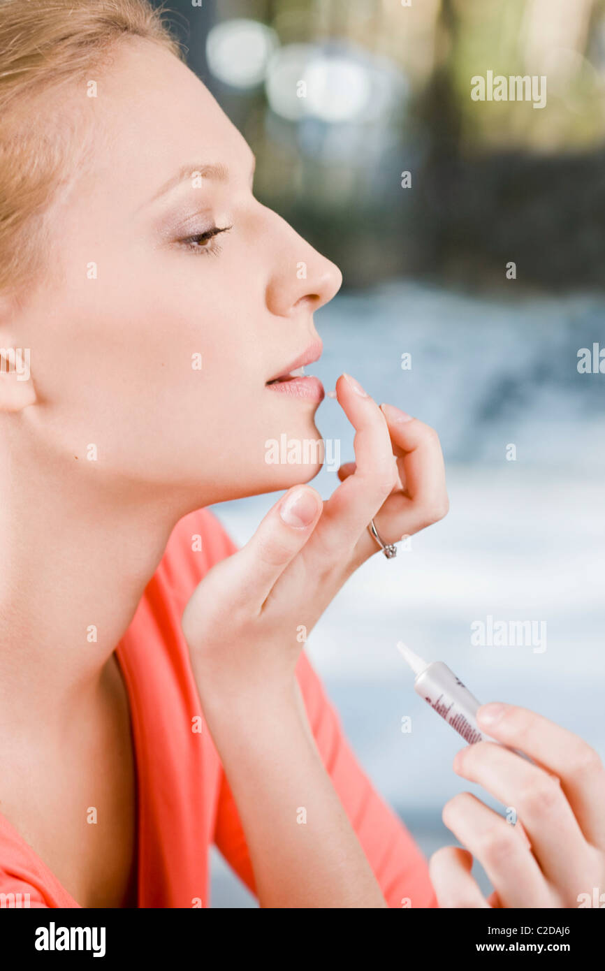 Woman applying ointment for cold sores Stock Photo