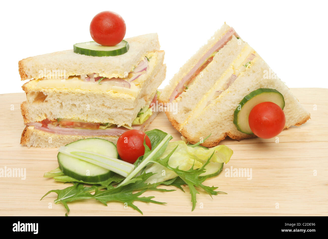 Ham and cheese club sandwich with salad garnish on a wooden board Stock Photo
