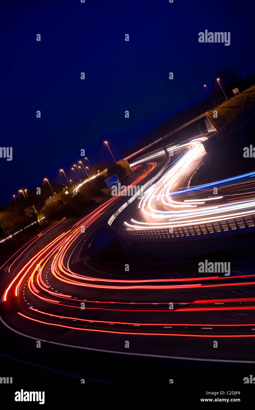 headlight trails of traffic travelling on the A1/M1 motorway at twilight near wetherby leeds yorkshire uk Stock Photo