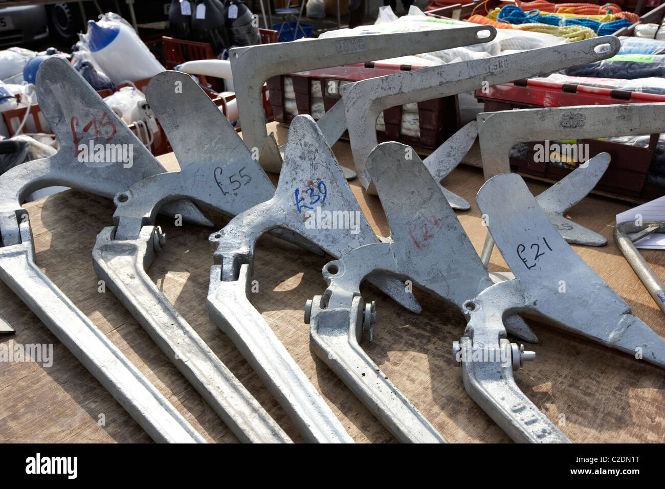 row of various weight plow plough anchors for sale at boat jumble sale in the uk Stock Photo