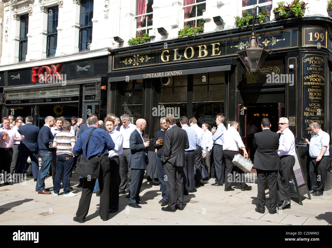 City workers drinking at lunchtime outside pub, London Stock Photo