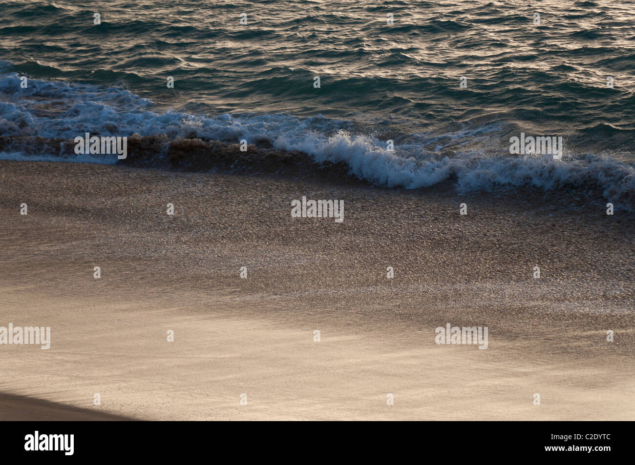 vague et plage au coucher de soleil Stock Photo
