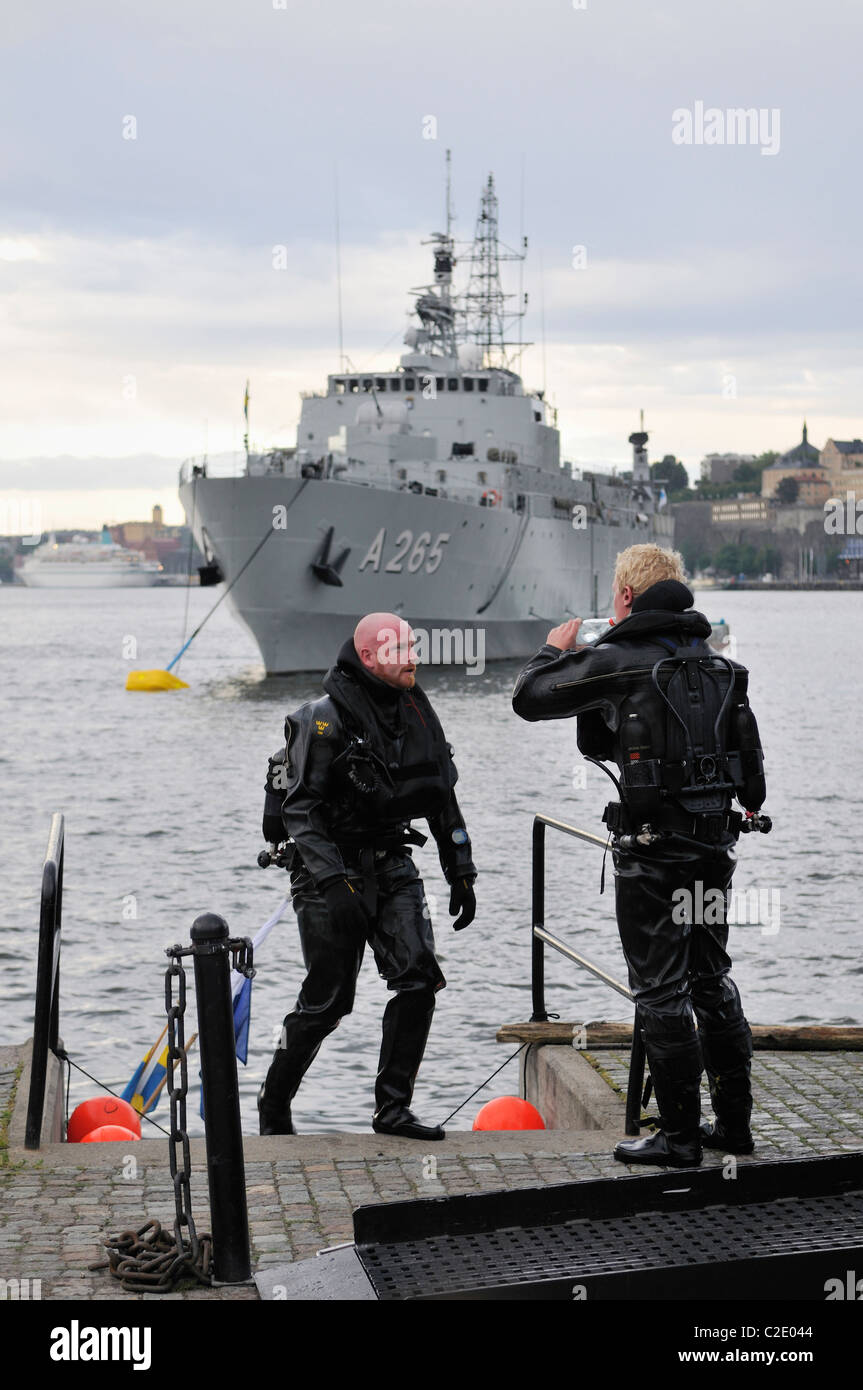 Scuba divers and battleship of the Swedish Navy at the harbor of Stockholm, Stockholms Lan, Sweden Stock Photo