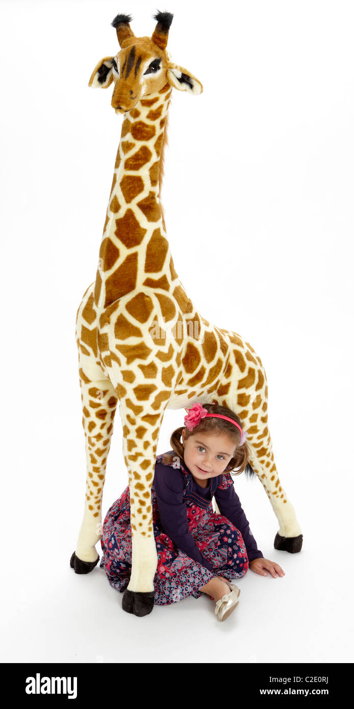 Little girl playing with stuffed giraffe toy Stock Photo