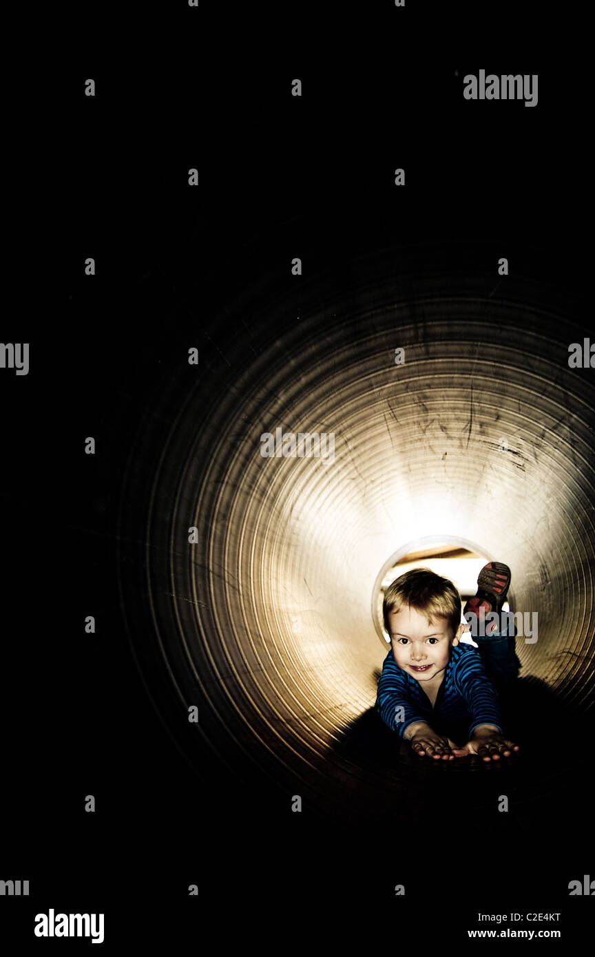 Boy having fun going down dark slide  (© Alan Davidson) Stock Photo