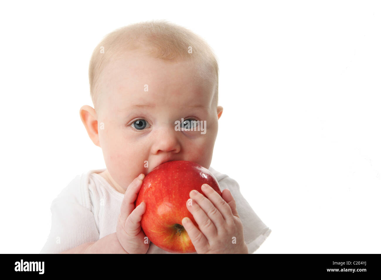 Portrait of a cute baby holding and tasting an apple Stock Photo Alamy