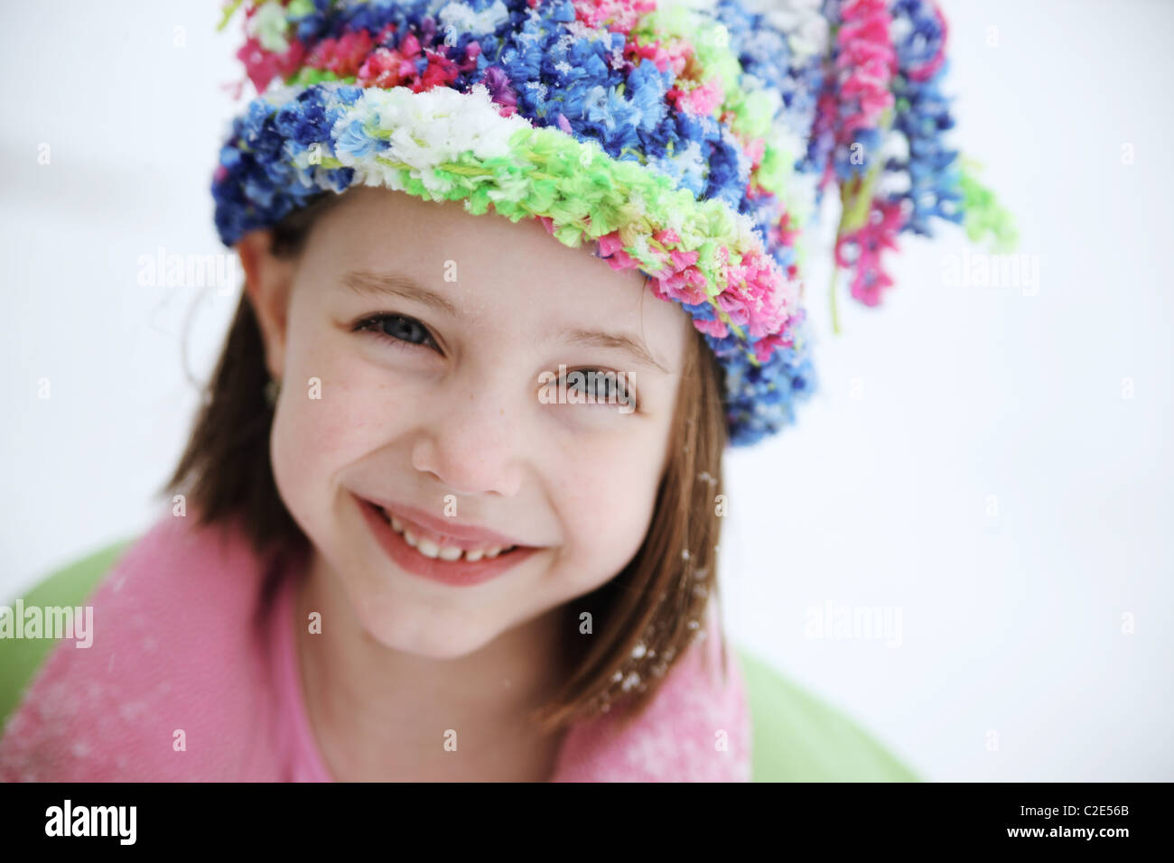 Cute little girl wearing a winter hat and coat outside in the cold snow