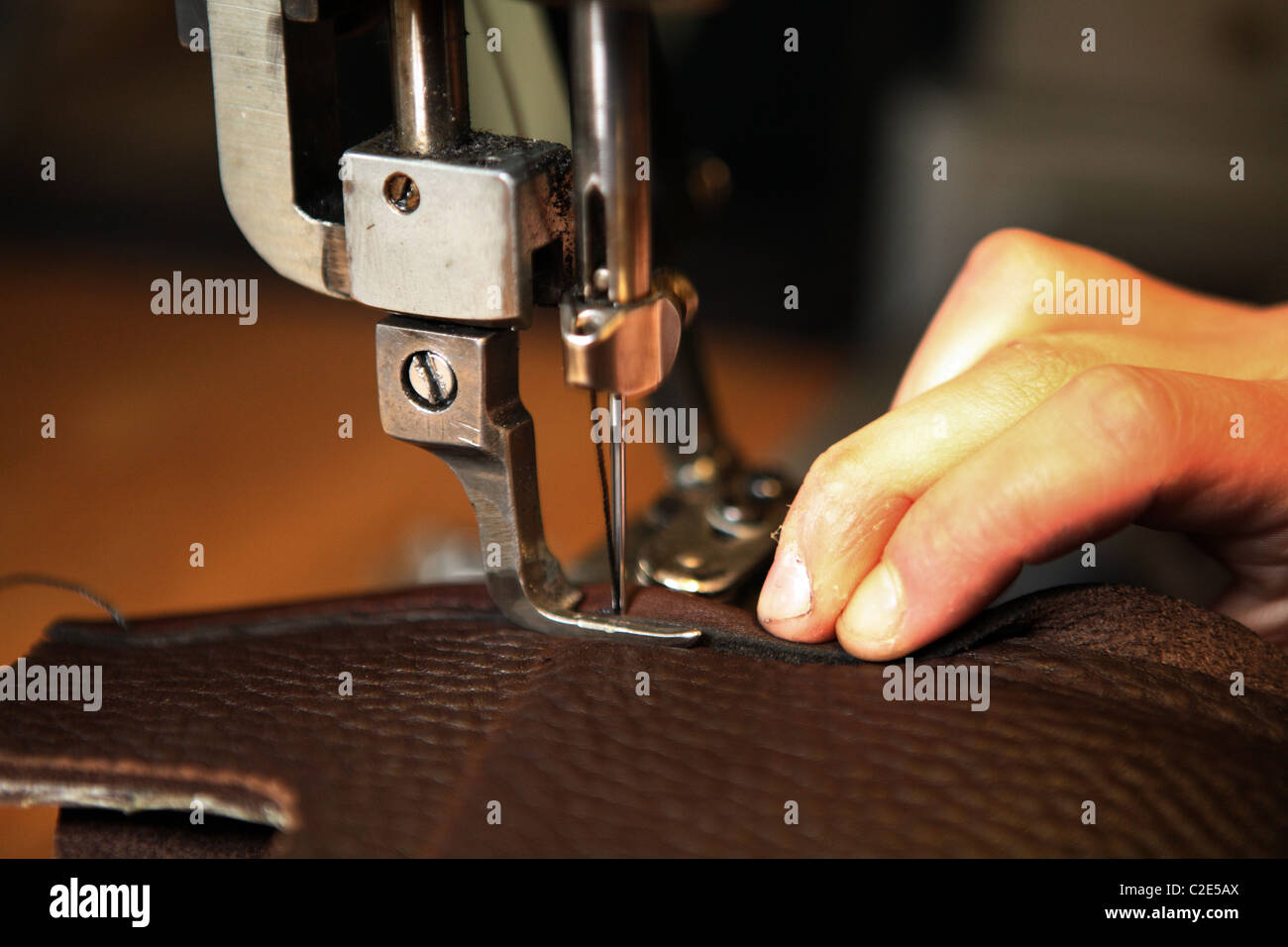 Sewing a seam on a piece of leather on a sewing machine Stock Photo
