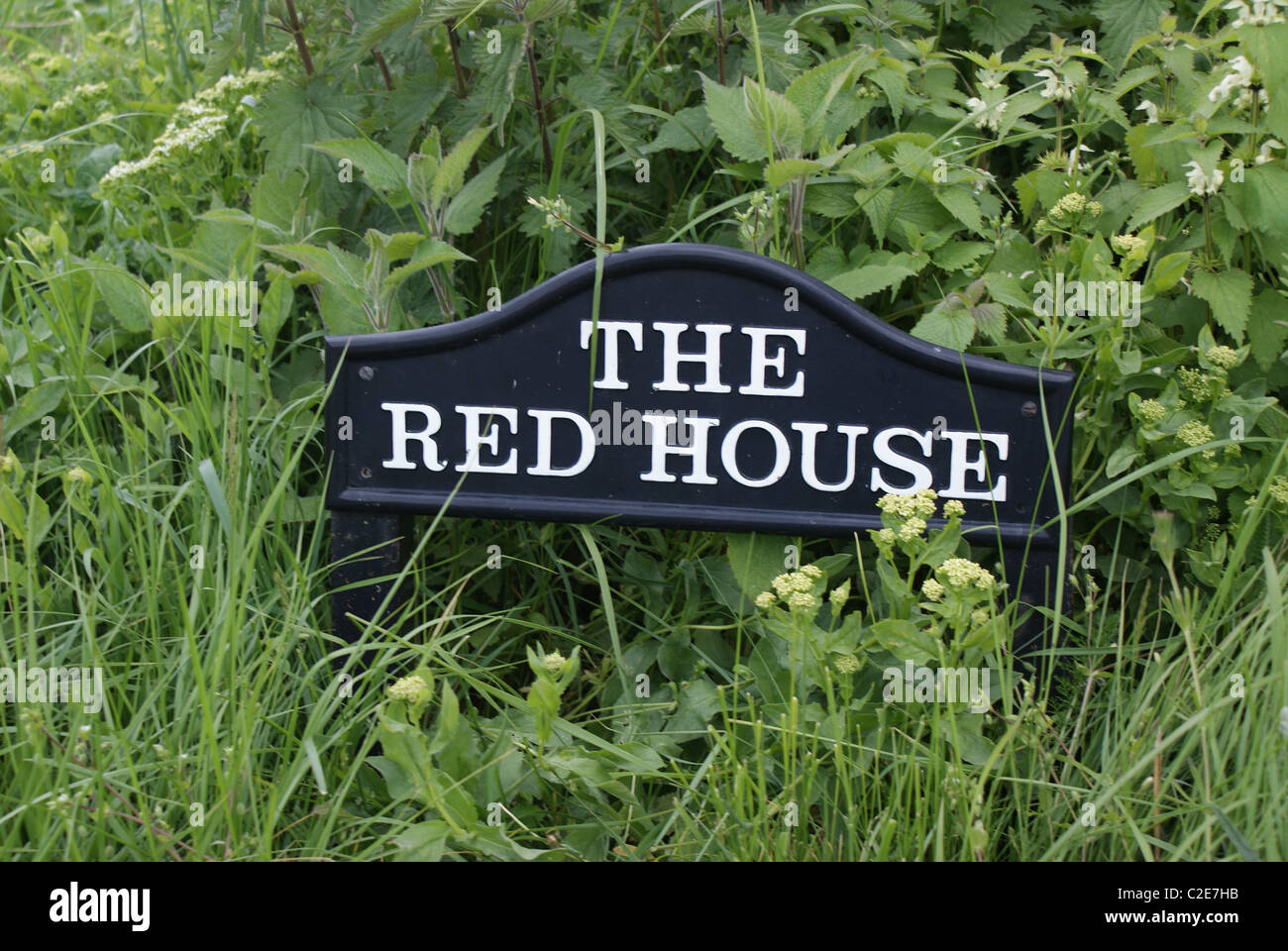 The Red House sign in grass Stock Photo