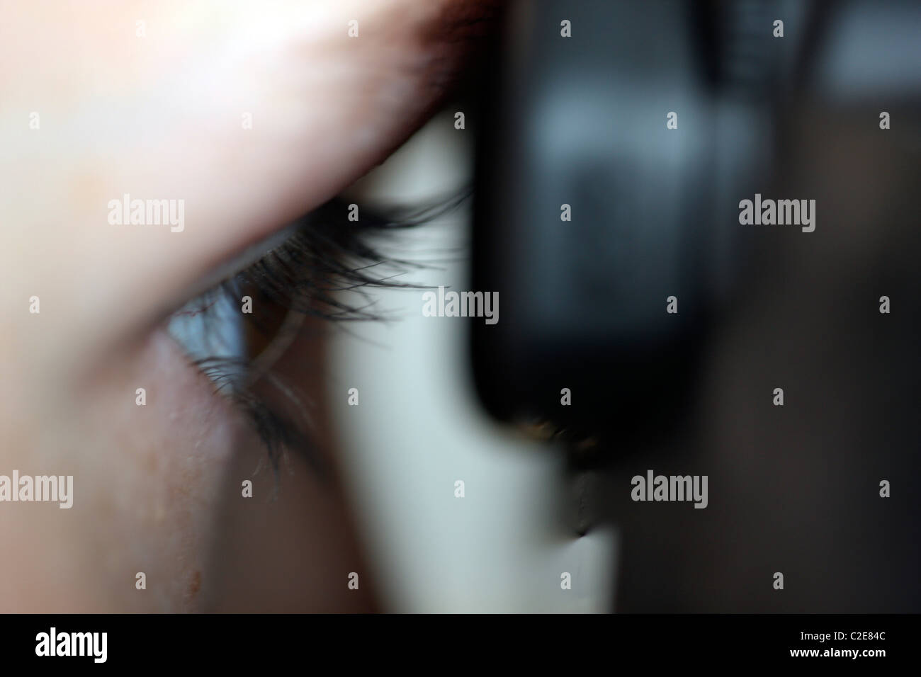 Person, female, looks through the viewfinder of a digital single lens reflex camera. Stock Photo