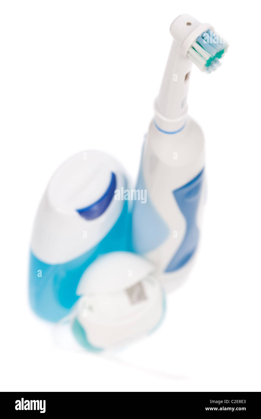 Electric toothbrush, toothpaste and dental floss isolated on white