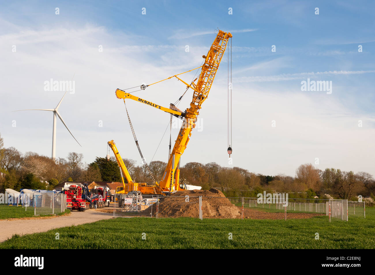 A massive crane used for constructing wind turbines with turbine behind