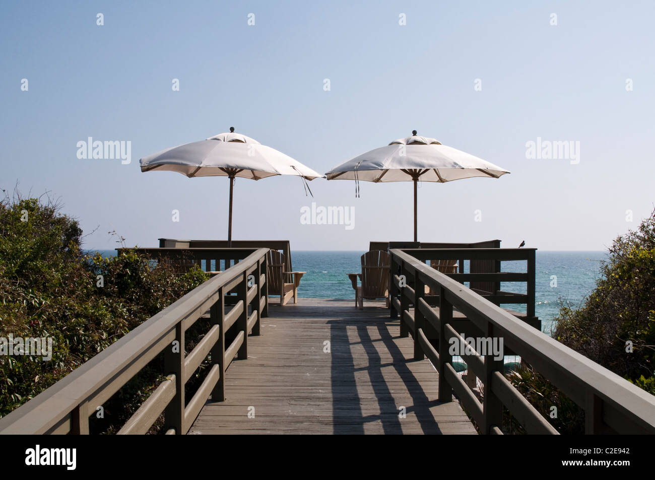 Two umbrellas offer shade and relaxation overlooking the Gulf of Mexico in Rosemary Beach, Florida. Stock Photo