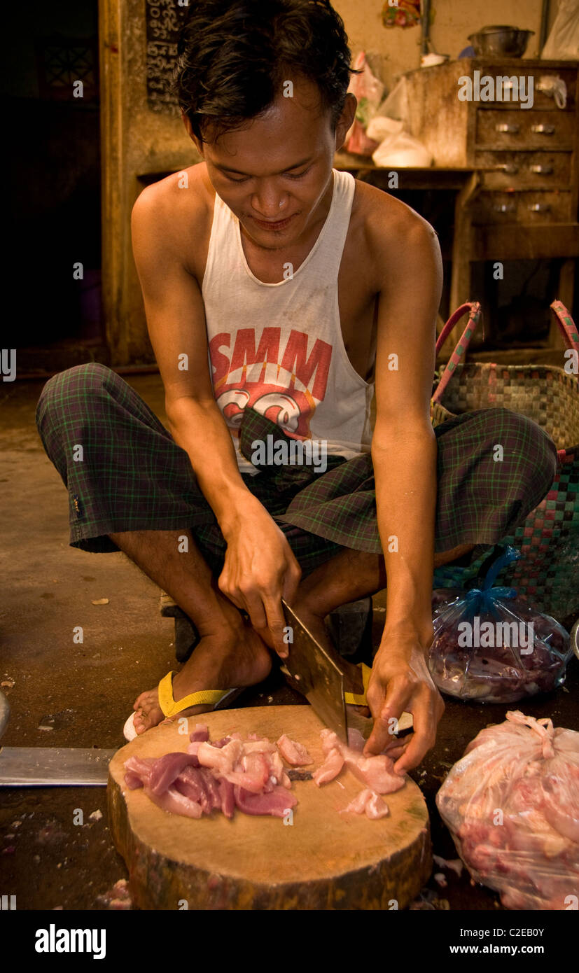 Pyay, Burma - Burmese boy  in a restaurant kitchen, working as a butcher. Stock Photo