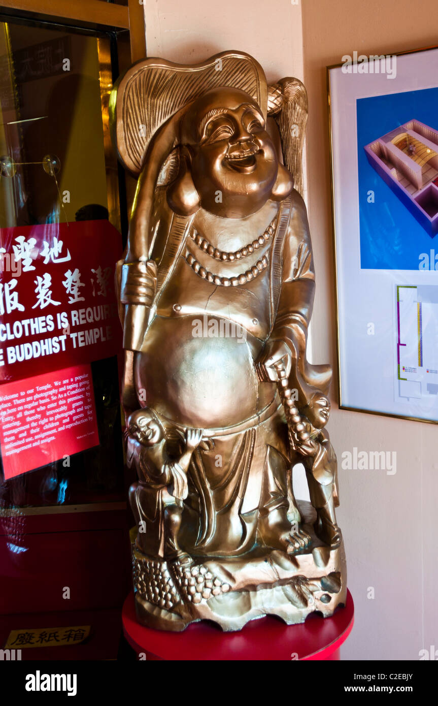 Obese, fatty, Laughing Buddhist monk statue in Chinese Mahayana Buddhist Temple, Chinatown, Manhattan, New York City, USA, Buddh Stock Photo