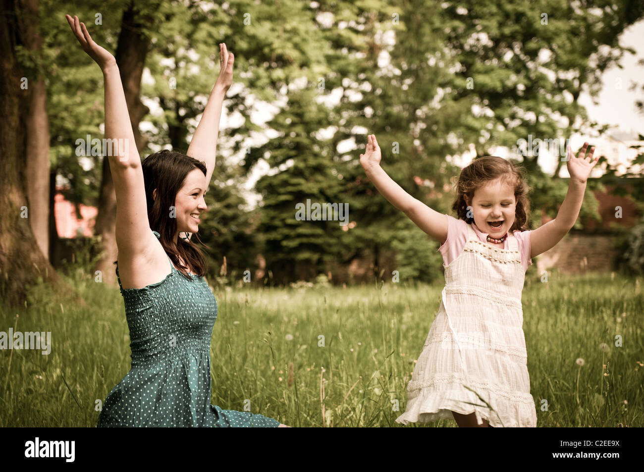 Small cute girl enjoying life with her mother outdoors in park Stock Photo