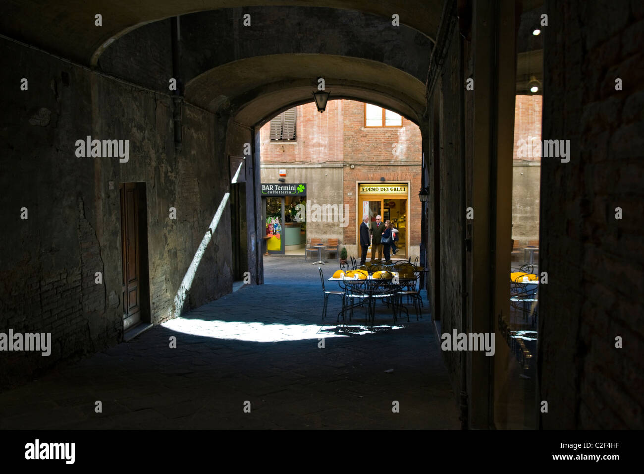 A Beam of Sunlight by Cafe in a Quiet Pedestrian Passageway in Siena Stock Photo