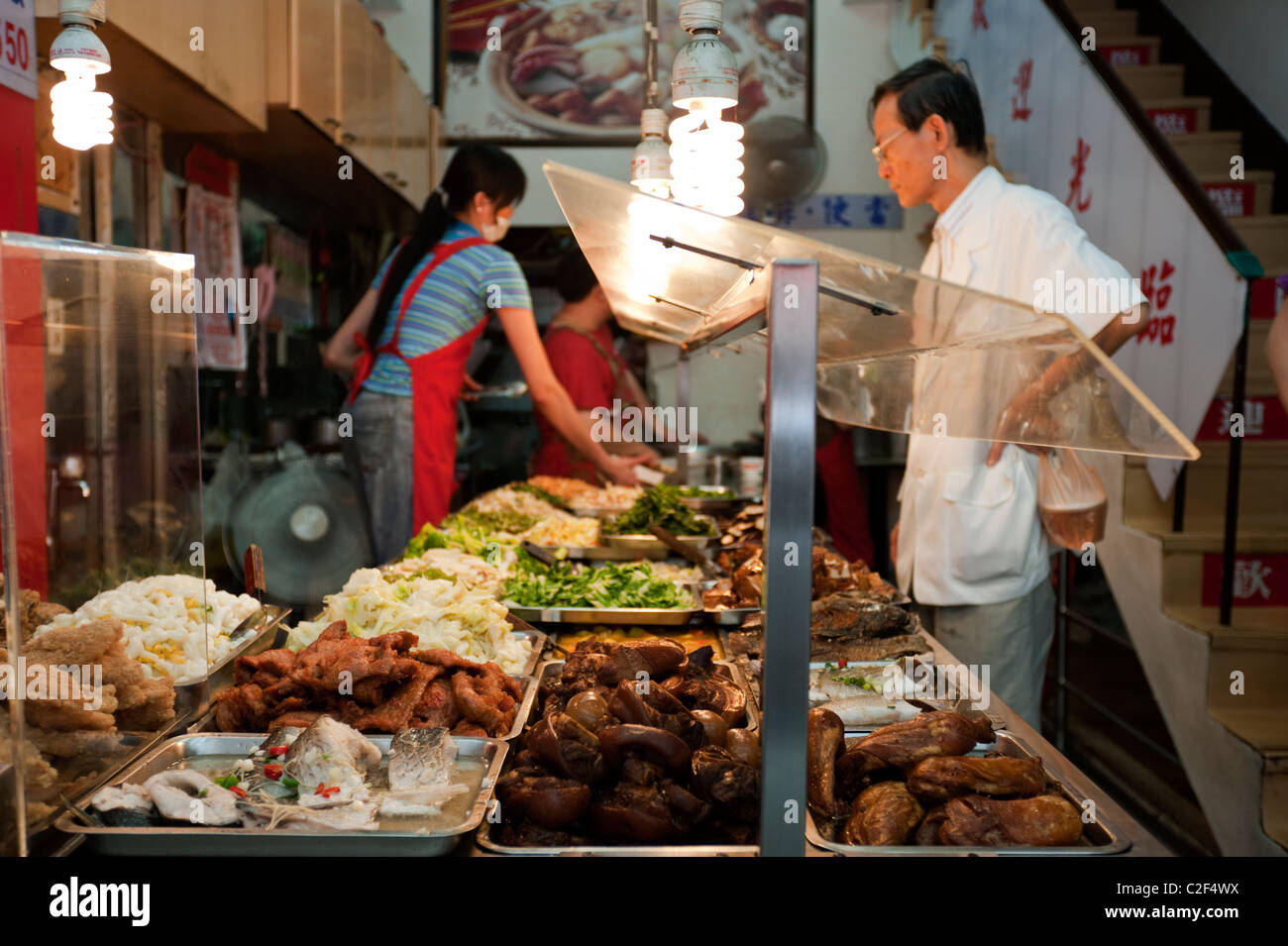 A man chooses dishes from a steam table at a Taiwanese restaurant in Taipei, Taiwan. Stock Photo