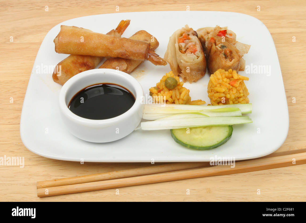 Selection of Chinese snacks on a plate on a wooden table Stock Photo