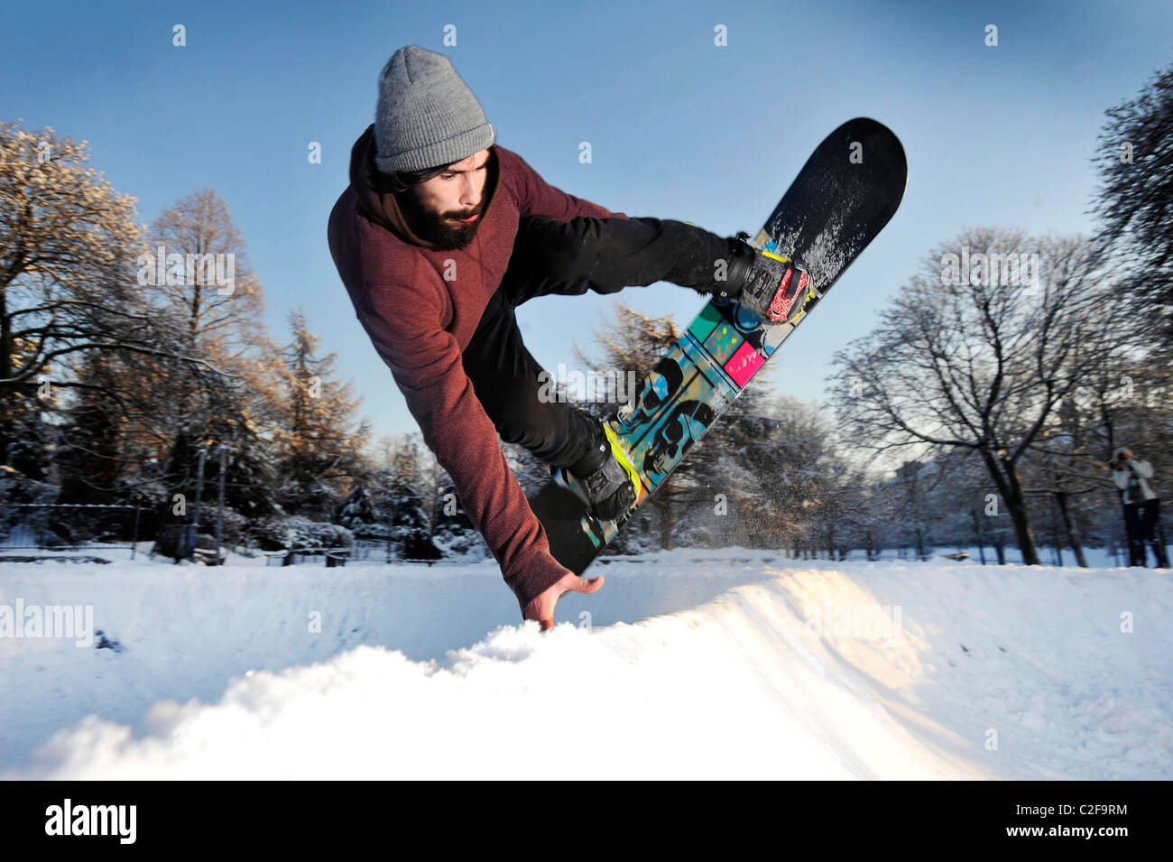 A man rides a snowboard on a snow covered skatepark in Kelvingrove Park