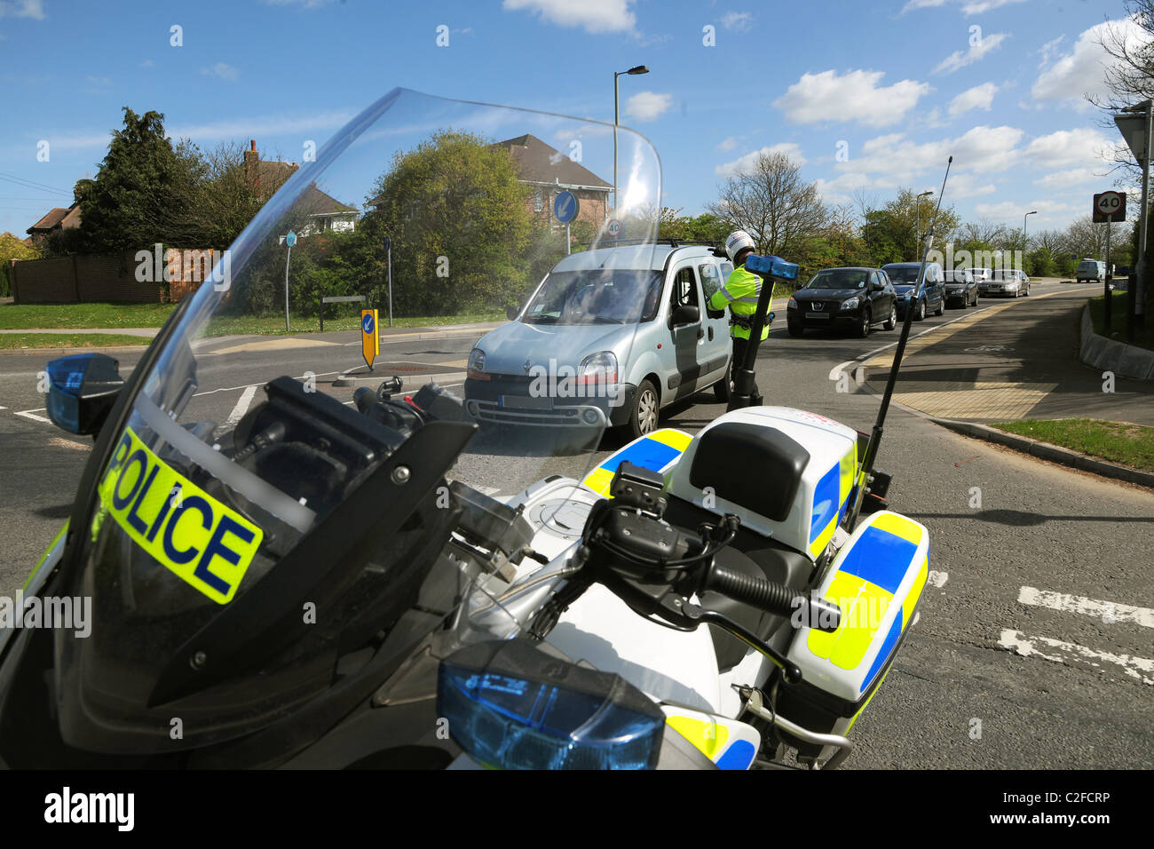Traffic is redirected by a police motorcyclist following a road closure because of an incident. Stock Photo