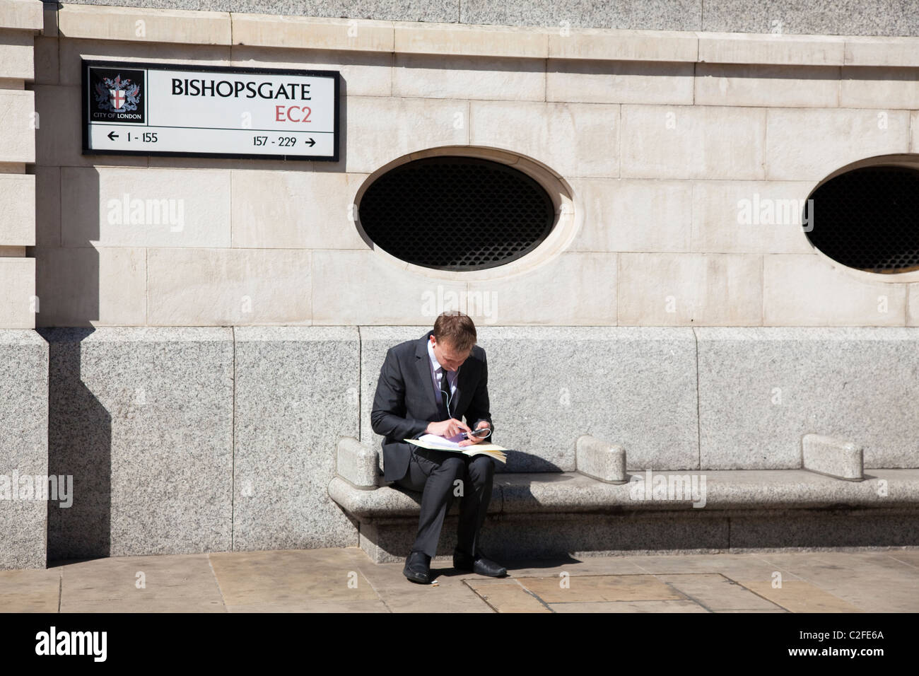 Man working outside in the sun, Bishopsgate, London, EC2, UK Stock Photo