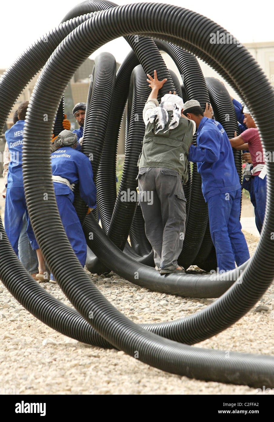 Afghan workers laying plastic pipes, Kunduz, Afghanistan Stock Photo