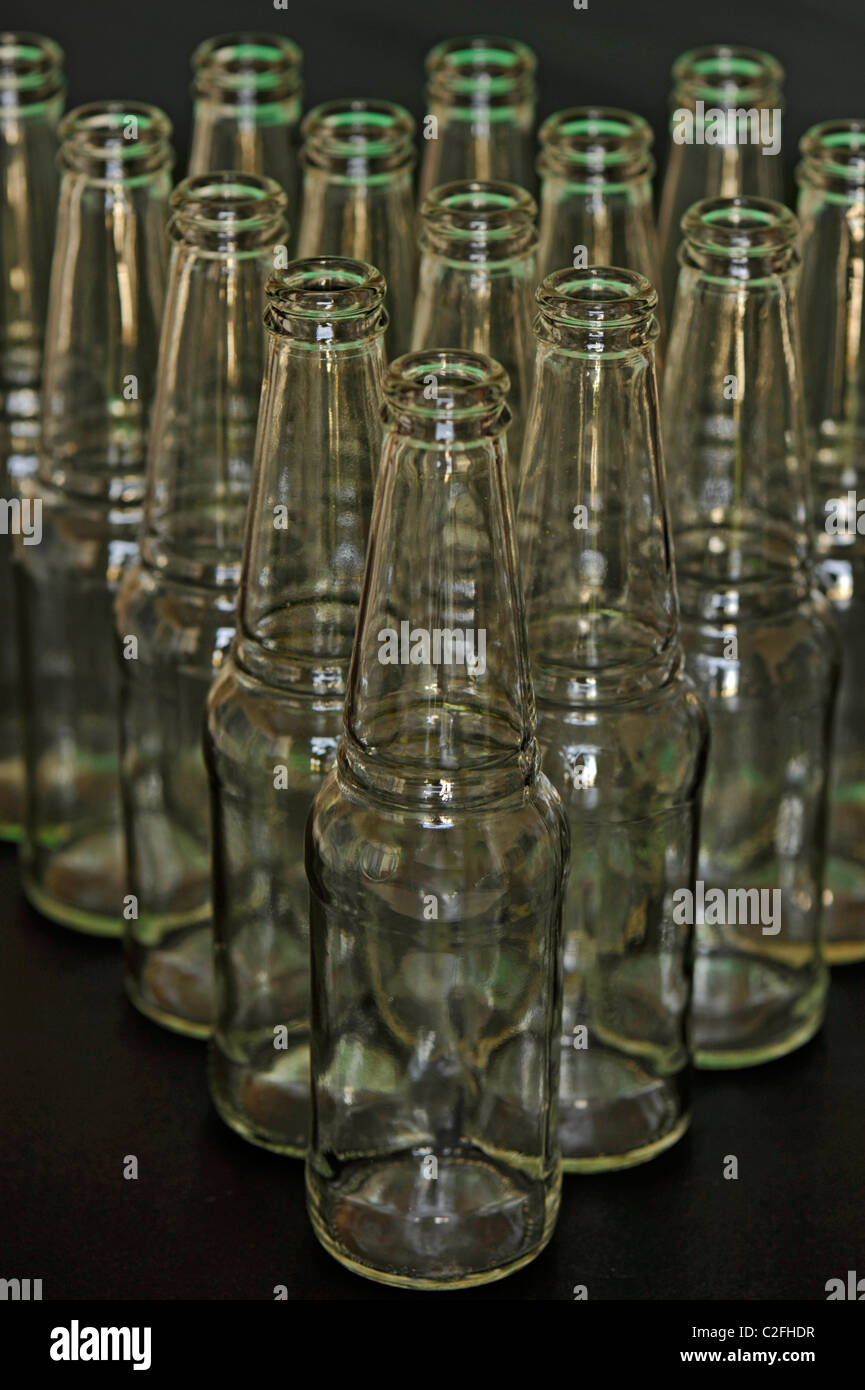 A group of empty clear glass bottles shot against a black background Stock Photo