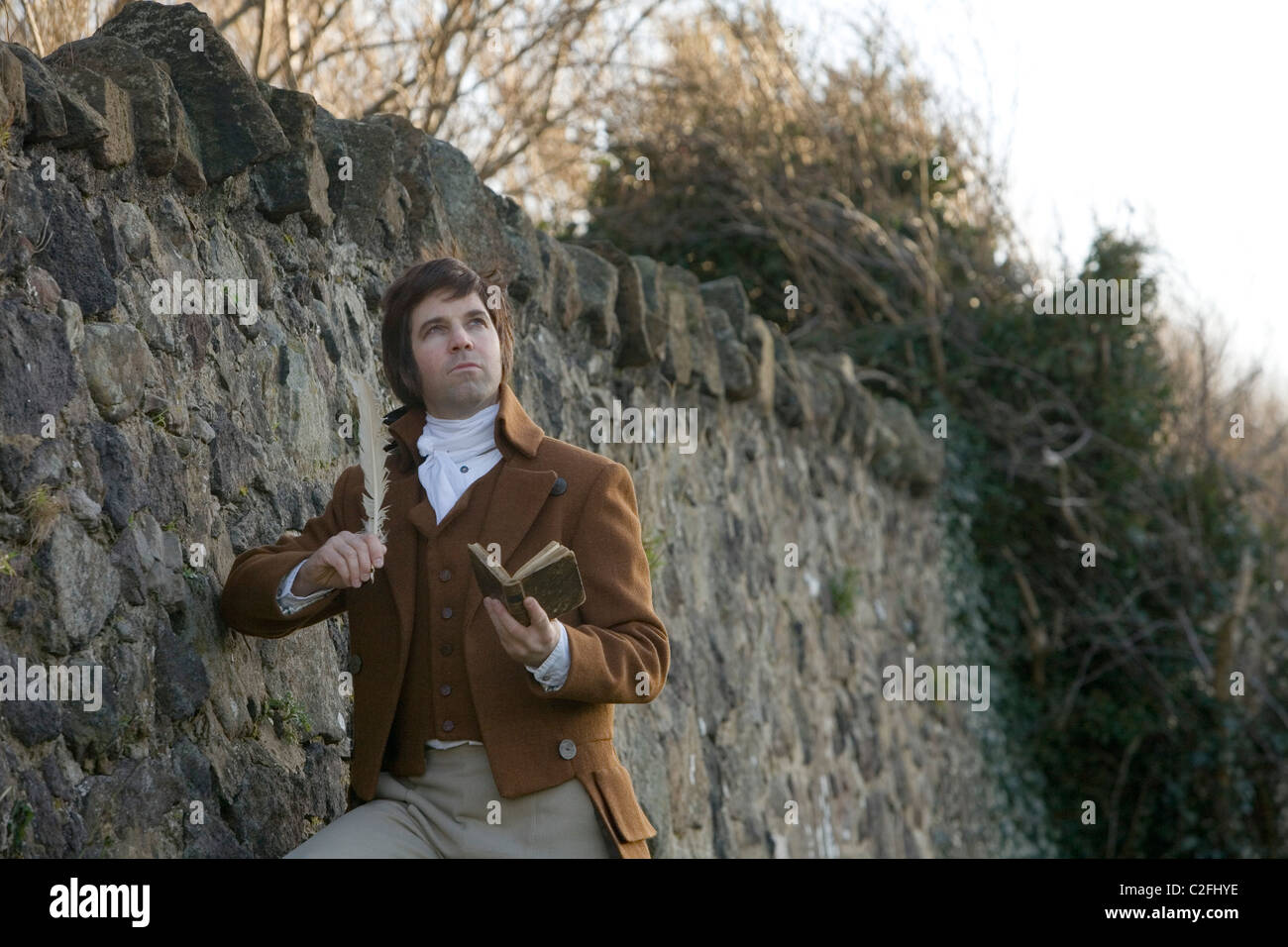 A tour guide playing the character of Robert Burns poses in thoughtful mood in a park. Stock Photo