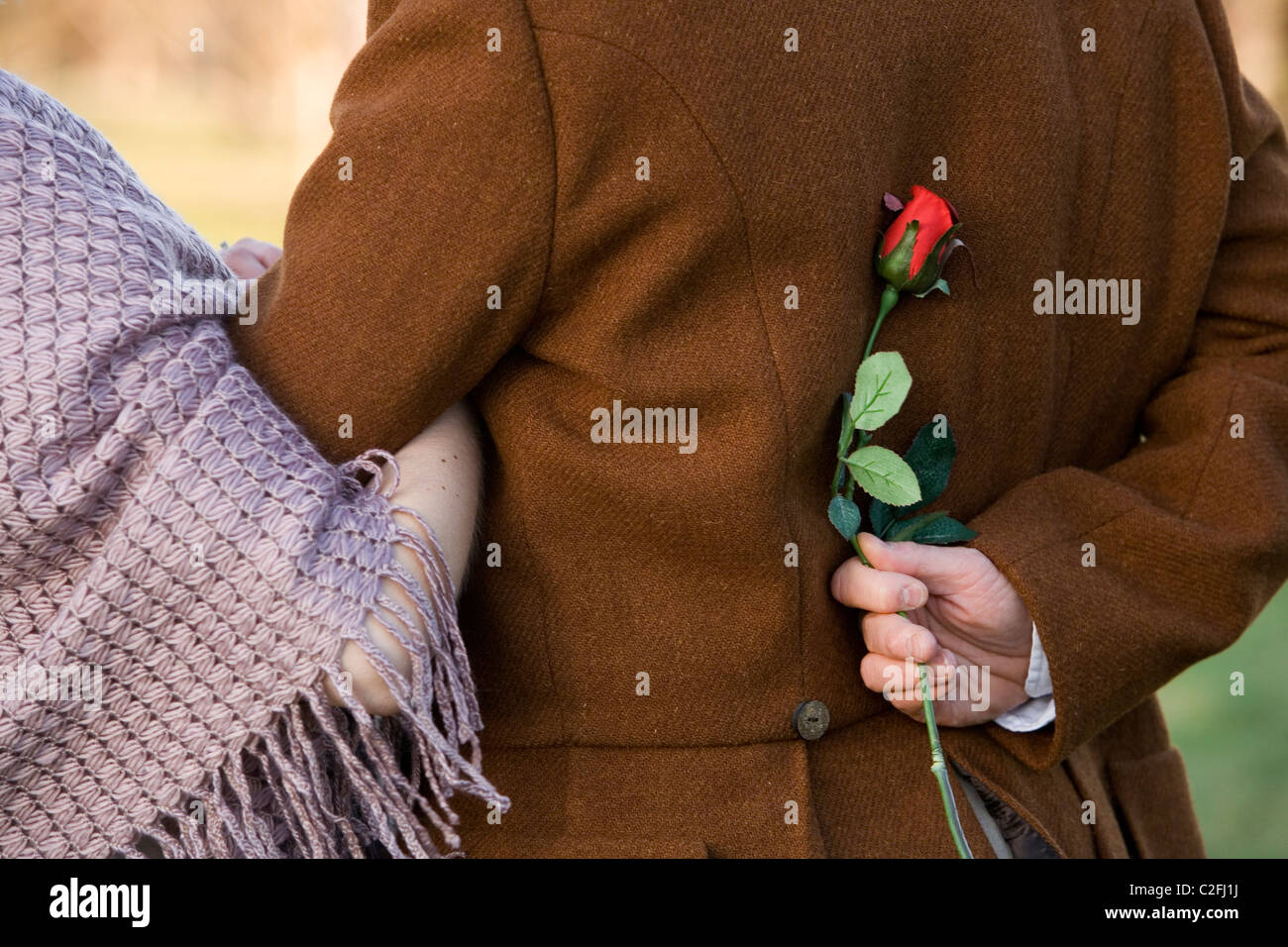 A tour guide dressed as Robert Burns poses in character with a young lady during a romantic walk in a park. Stock Photo