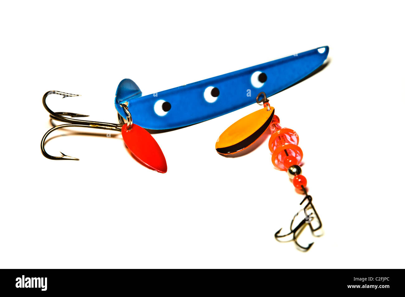 Brightly painted metal and rubber deep sea fishing lures with hooks. Stock Photo