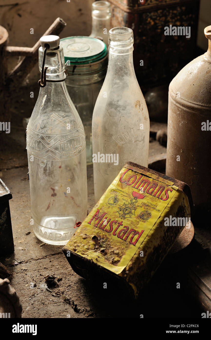 A Colman's Mustard tin and some old glass bottles in a shed Stock Photo Alamy