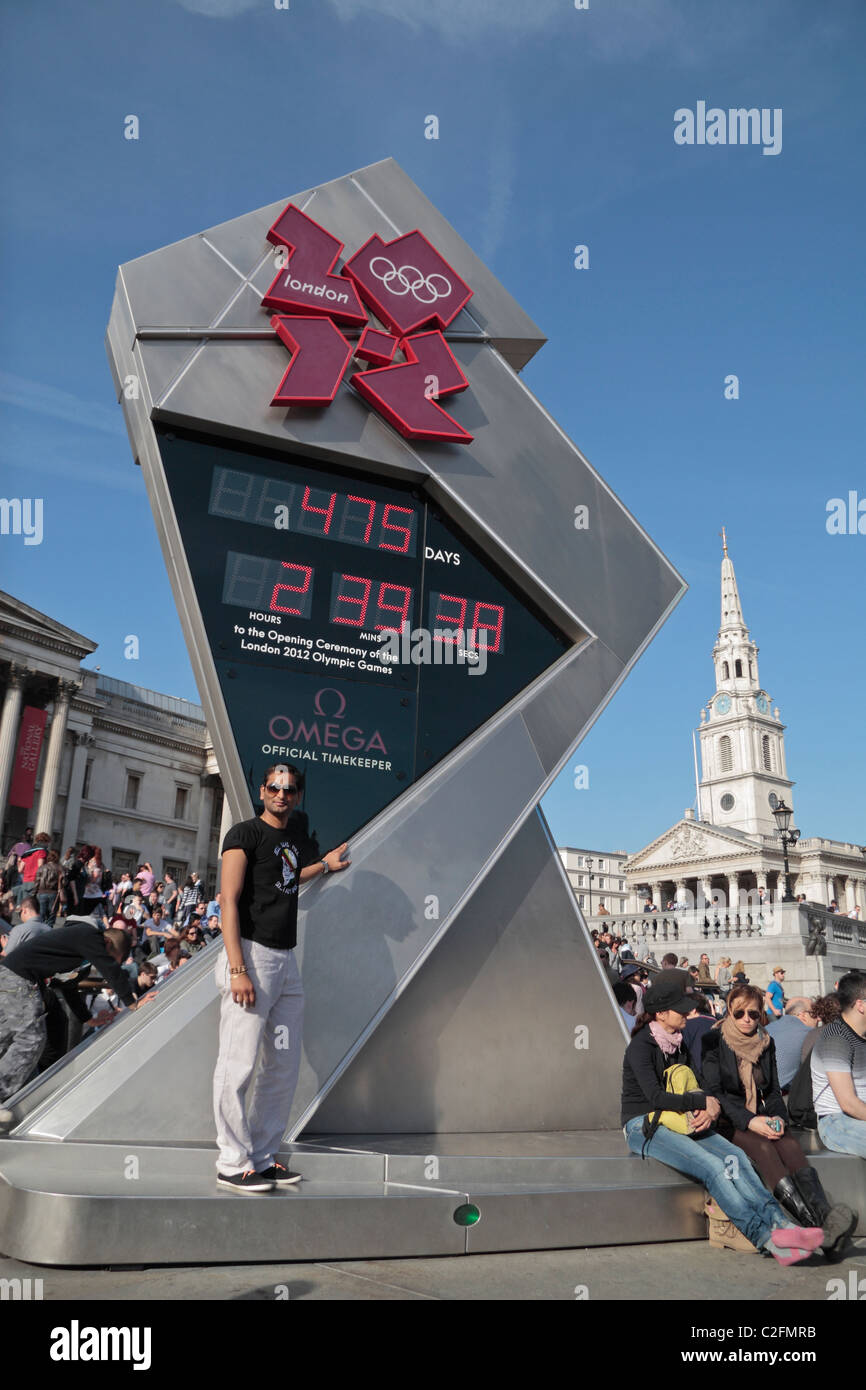 Tourist posing in front of the clock in Trafalgar Square London