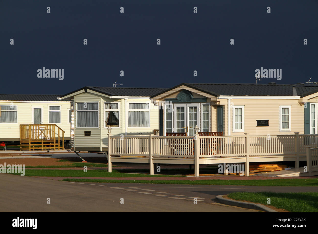 Large site holiday and residential caravans with dark thunder clouds. Stock Photo