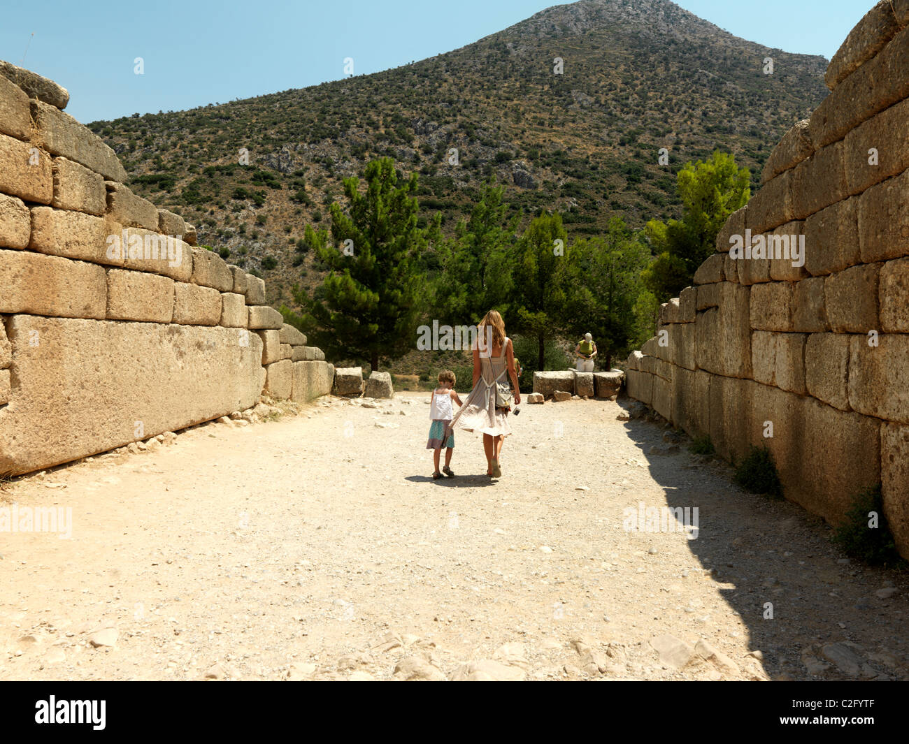 Mycenae Peloponnese Greece Mother And Daughter Coming out Of Tholos Tomb Treasury of Atreus Stock Photo