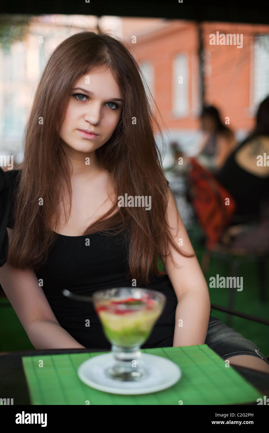 Young woman with ice cream at sidewalk cafe Stock Photo