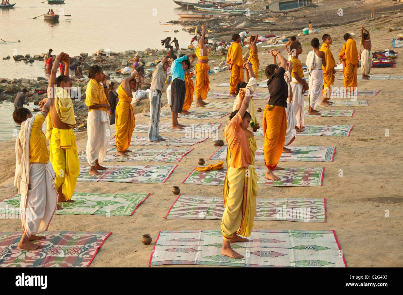 Students practice a Yoga session in the morning by the Ganges in