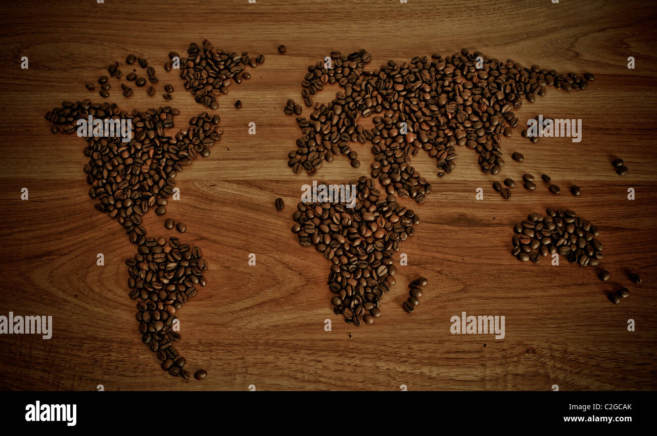 Dramatic photo of world map made of coffee beans. White cup with hot drink. Stock Photo