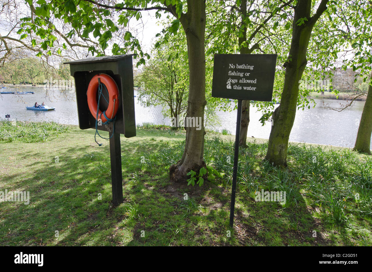 Life ring and 'No bathing fishing or dogs allowed in this water' sign. Regent's Park lake Camden London Uk. Stock Photo