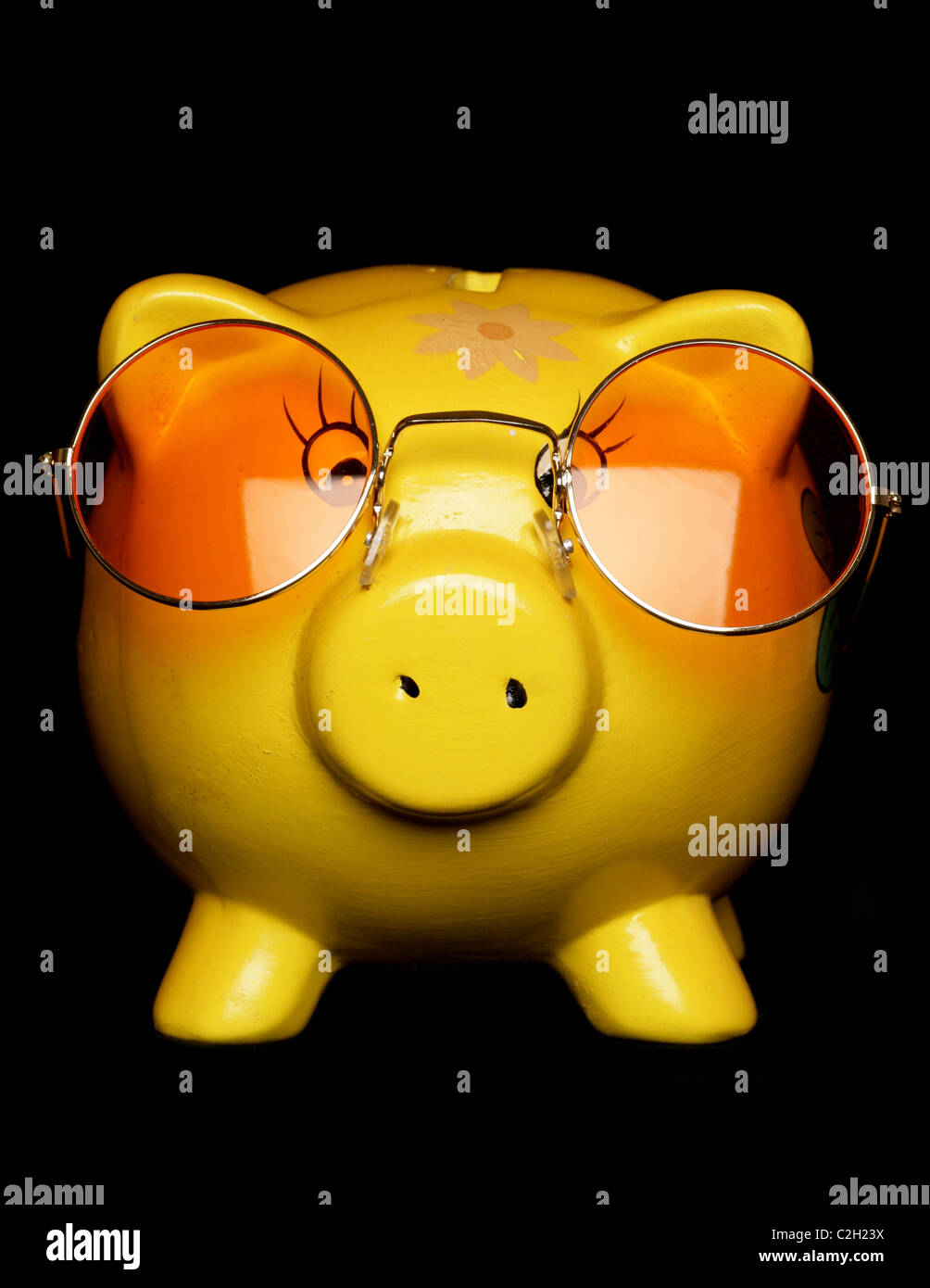 yellow piggybank with sunglasses studio cutout Stock Photo