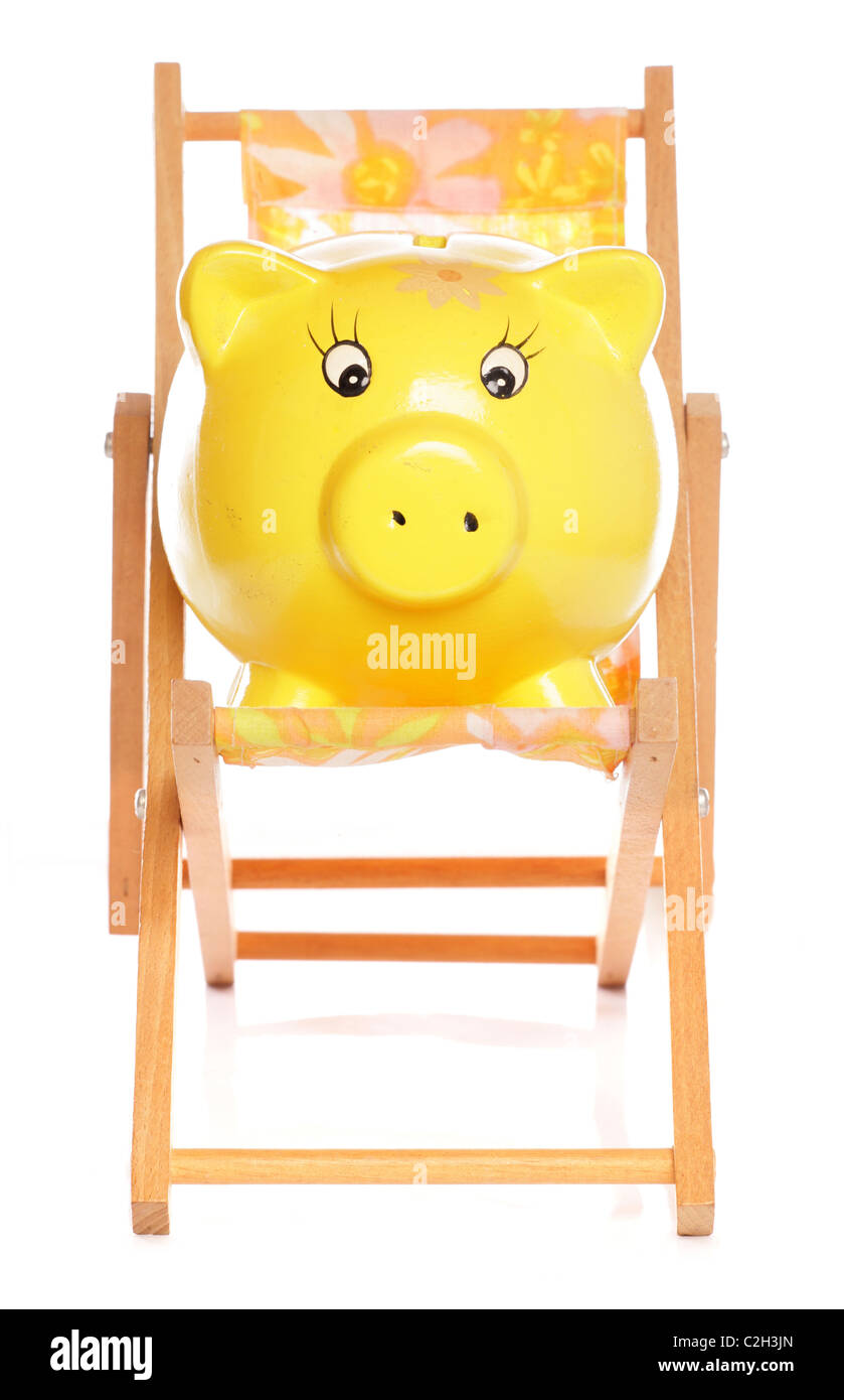 yellow piggybank on deckchair studio cutout Stock Photo