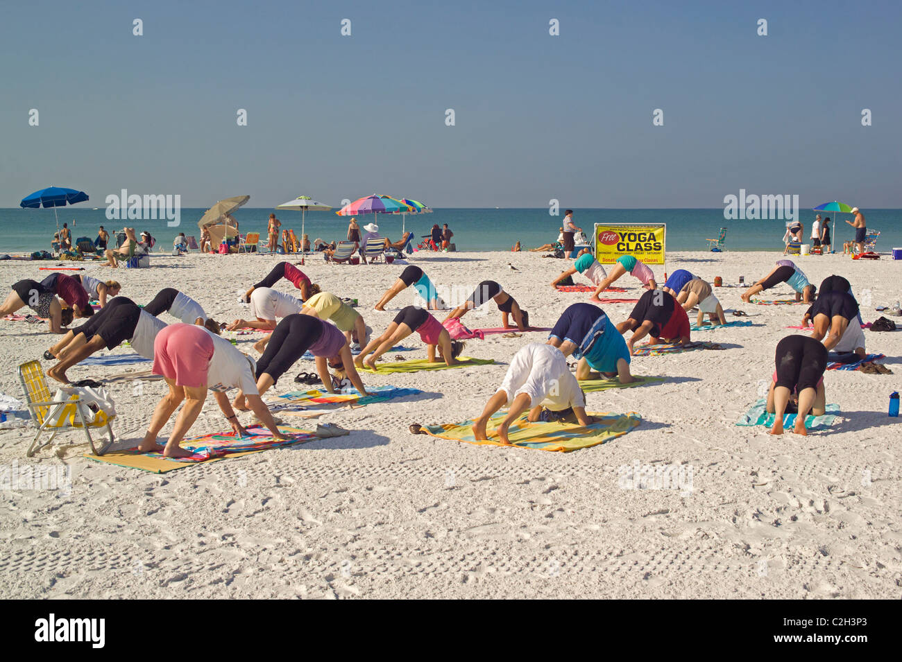 Yoga classes are held on the white sand beach of Siesta Key, a resort barrier island on the Gulf of Mexico at Sarasota, Florida. Stock Photo