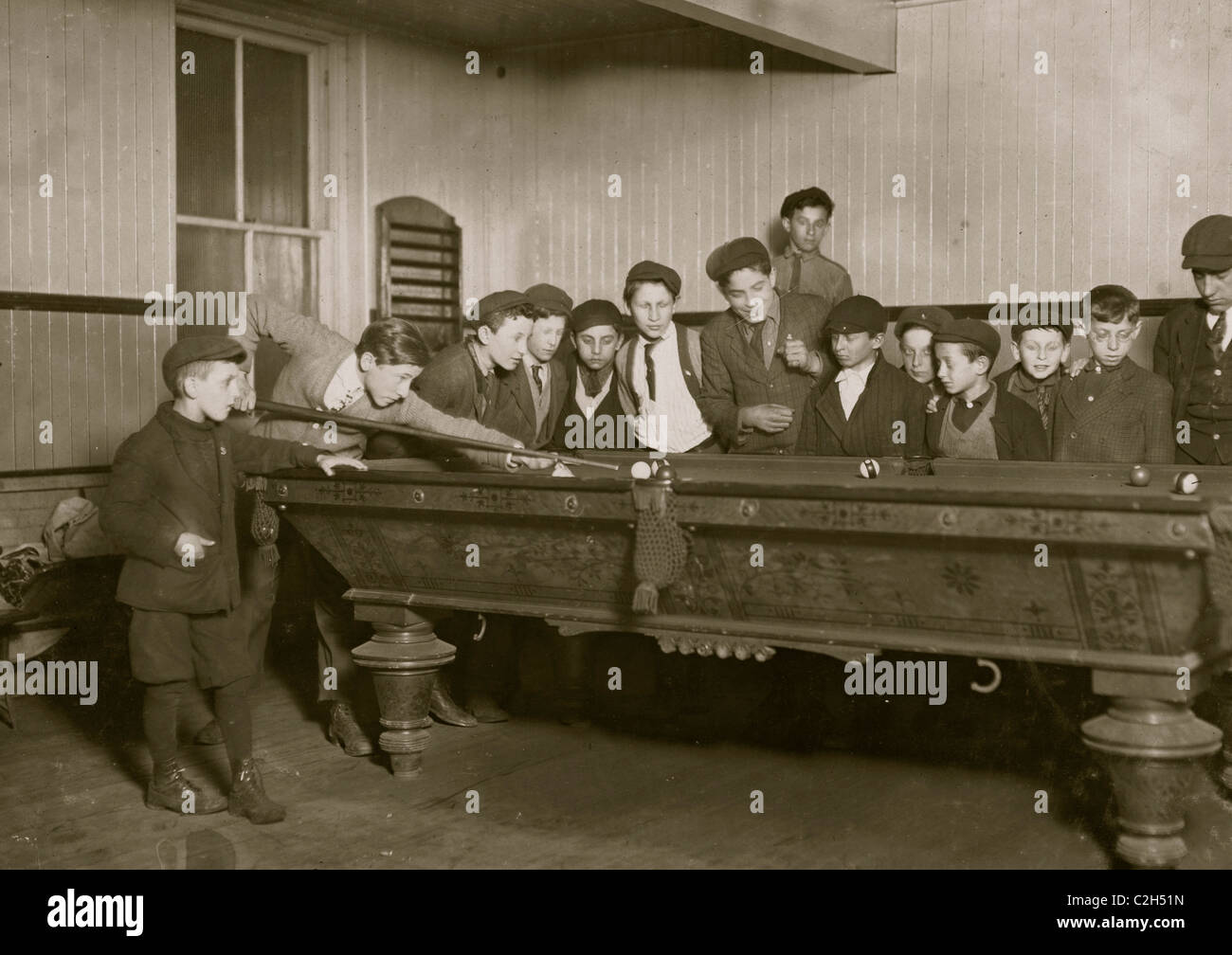 One way to control the street boys. A common scene in the Bancroft-Foote Boys Club, Playing Pool Stock Photo