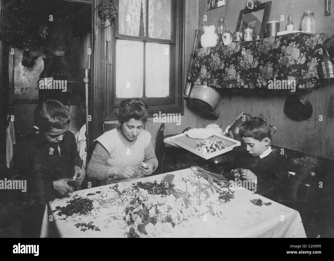 Mrs. A.L.A. She & her 3 children - 11, 9, & 6 yrs old work at flower making. Stock Photo