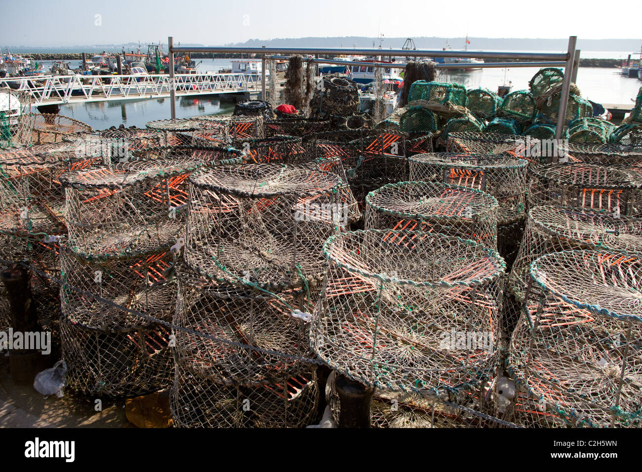 Fishing boats Poole Harbour with crab fishing pots in foreground Stock