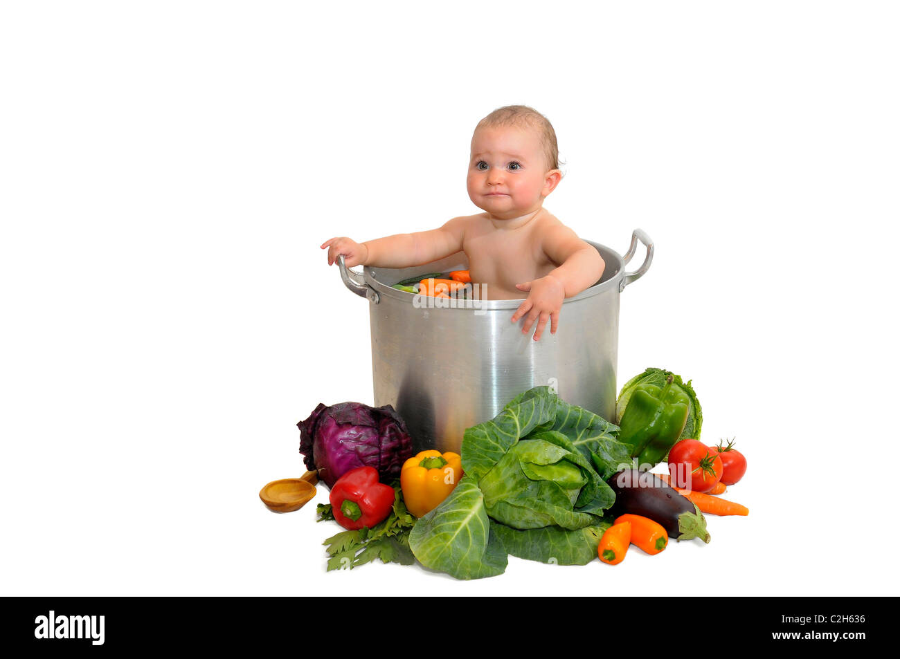 Beautiful young baby in a pan with vegetables Stock Photo