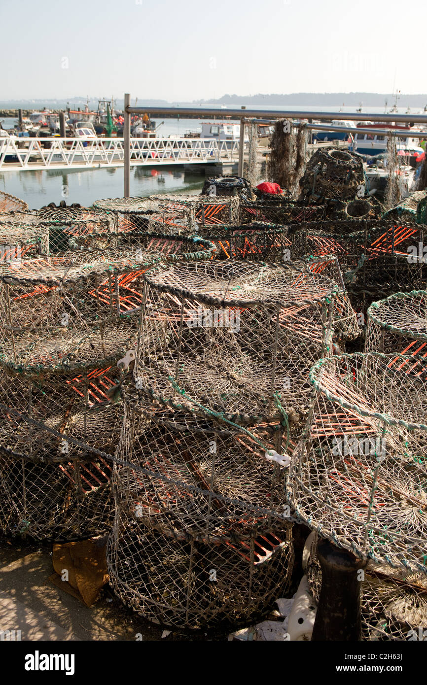 Fishing boats Poole Harbour with crab fishing pots in foreground Stock