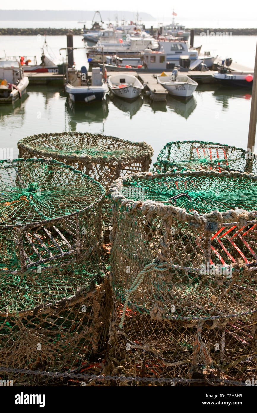 Fishing boats Poole Harbour with crab fishing pots in foreground Stock
